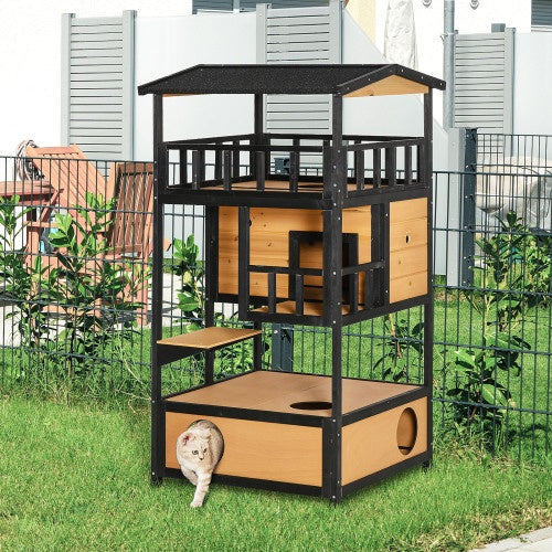 Wooden cat house set up outdoors on grass with cat exiting bottom den